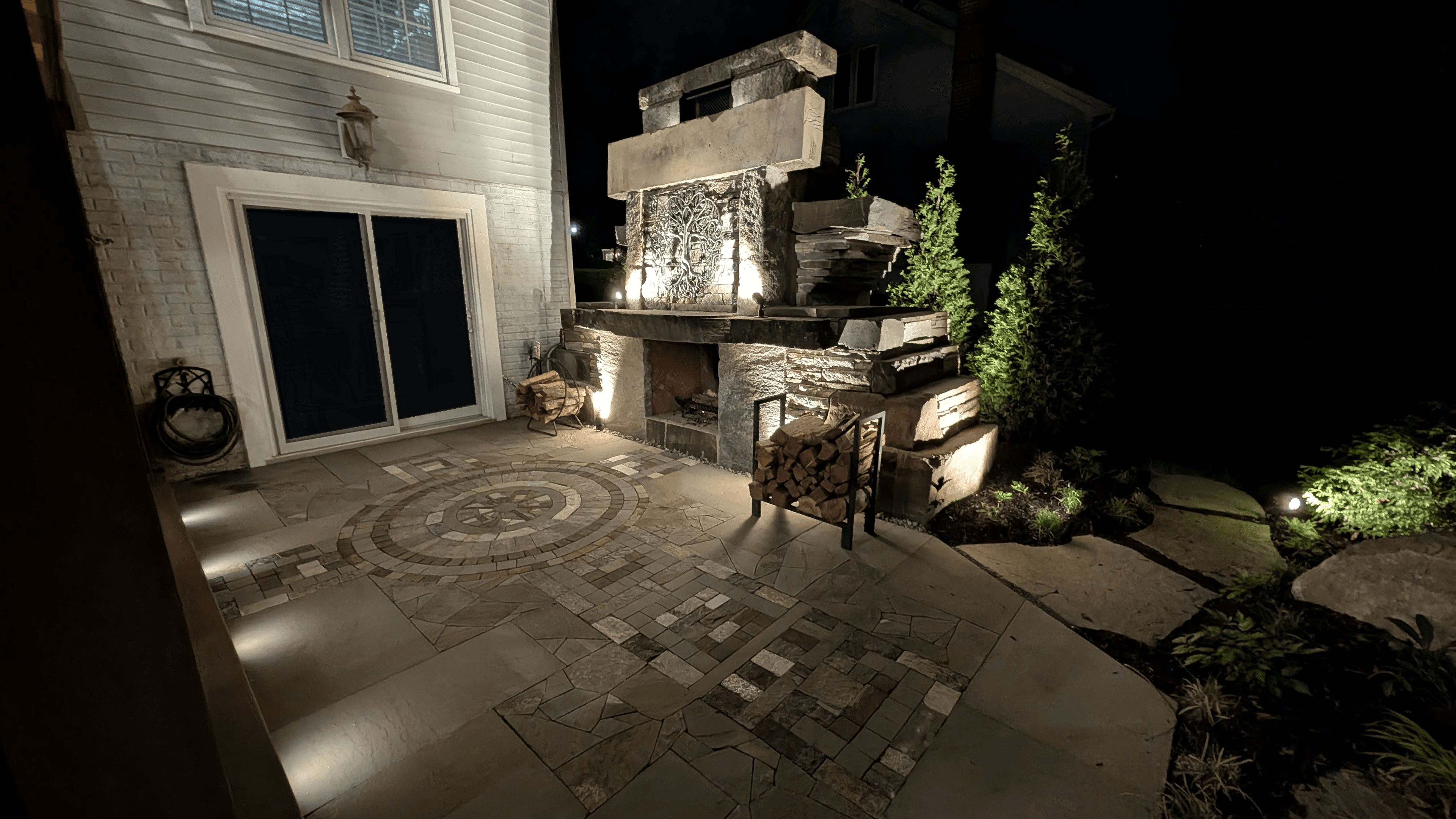 Project Wildfire outdoor fireplace, Celtic cross patio, and stonework lit at night